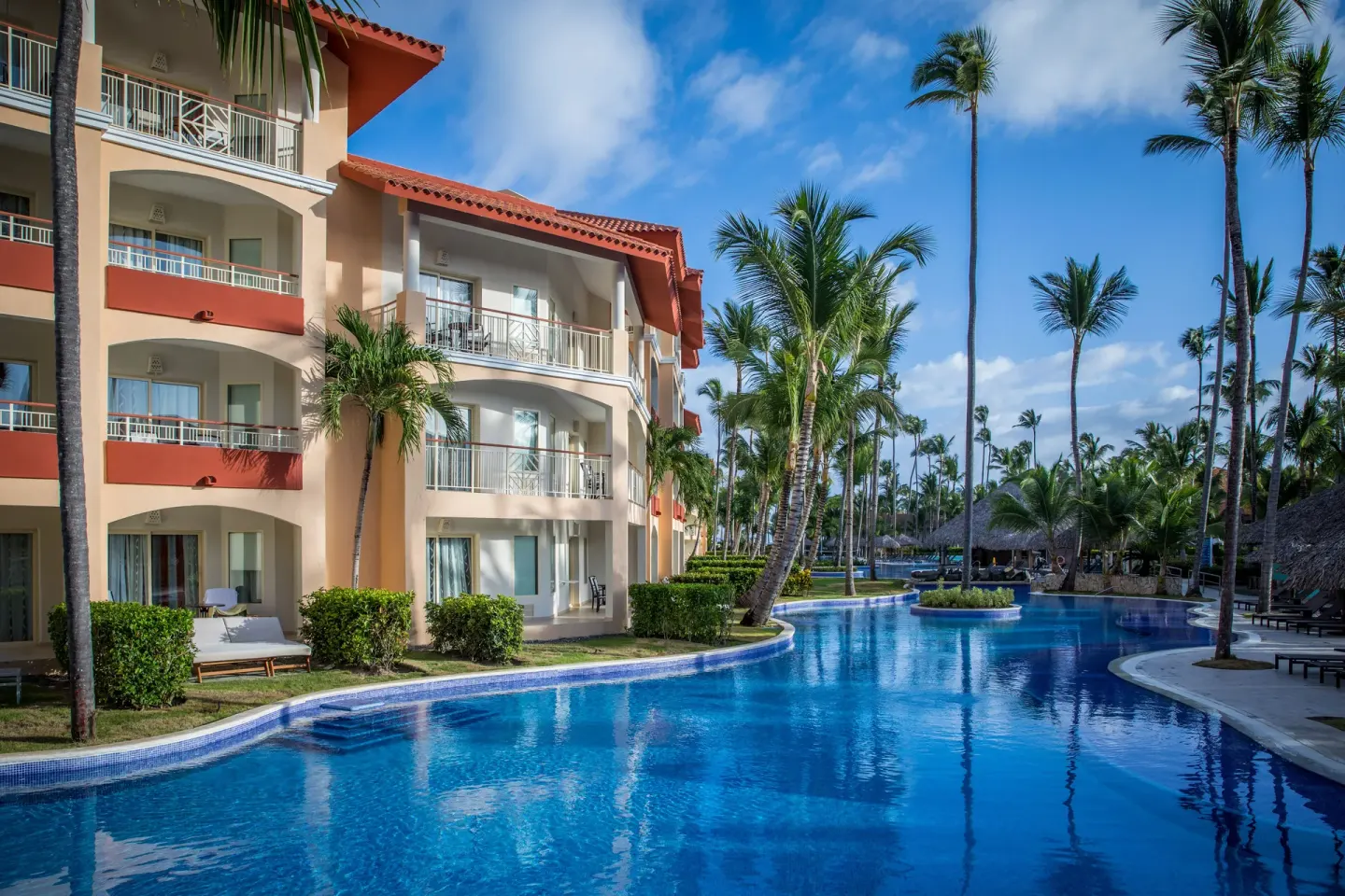 Curving pool beside guest-room balconies at Majestic Elegance Punta Cana.