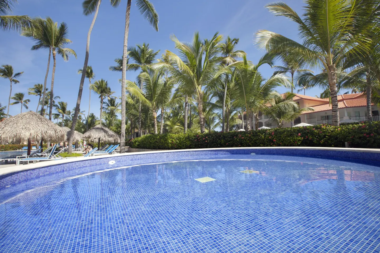 Quiet tiled pool bordered by palms at Majestic Elegance Punta Cana.