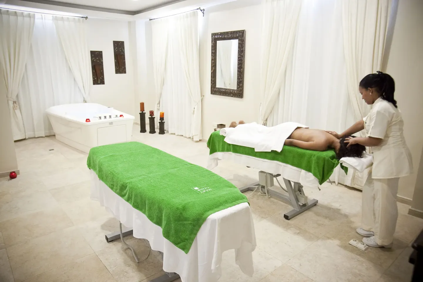 A spa treatment room with massage tables is shown at Majestic Elegance Punta Cana.