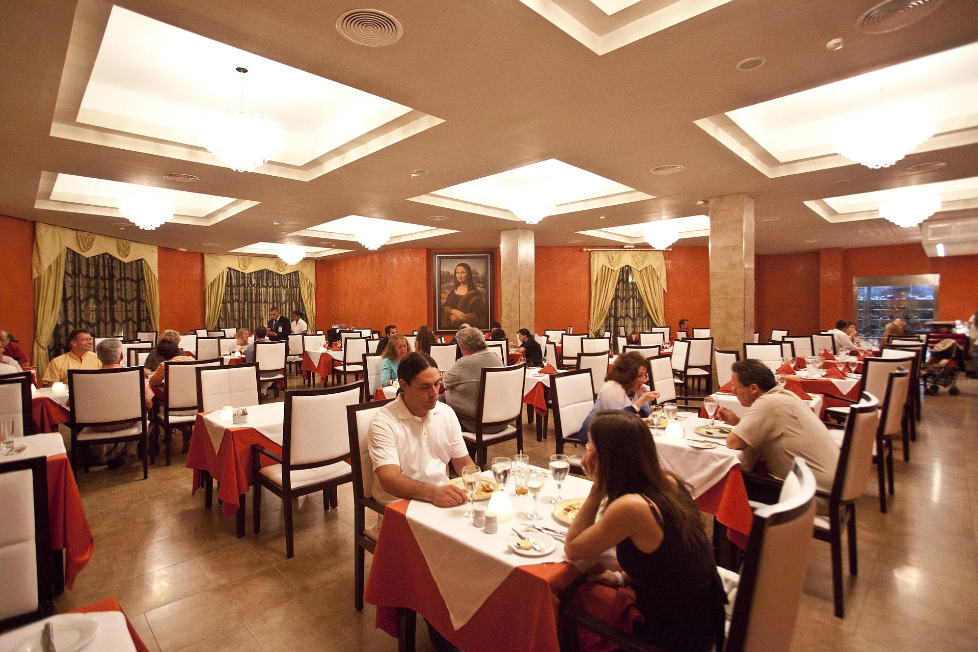 Formal restaurant dining room with red table accents at Majestic Elegance Punta Cana.