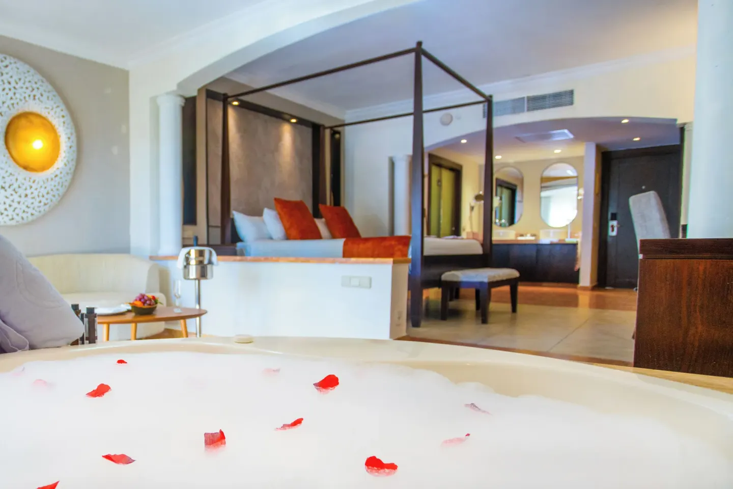 Jacuzzi tub with rose petals facing the king bed at Majestic Elegance Punta Cana.