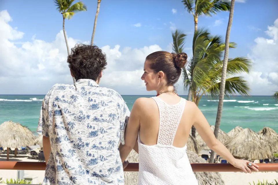 Couple on an ocean-view balcony at Majestic Elegance Punta Cana.