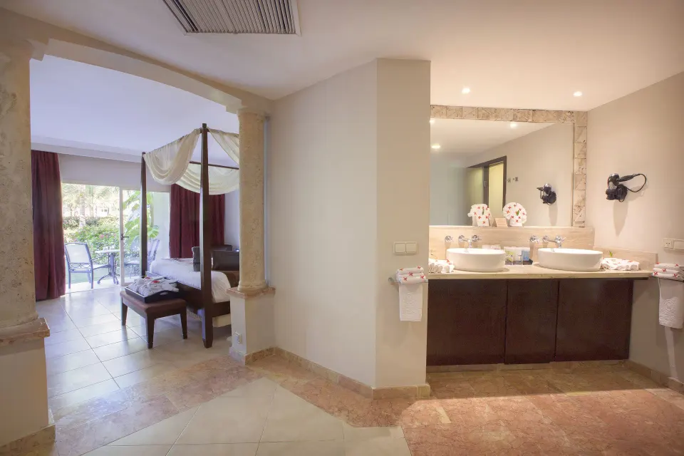 Elegance Club One Bedroom Suite bathroom and canopy bed at Majestic Elegance Punta Cana.
