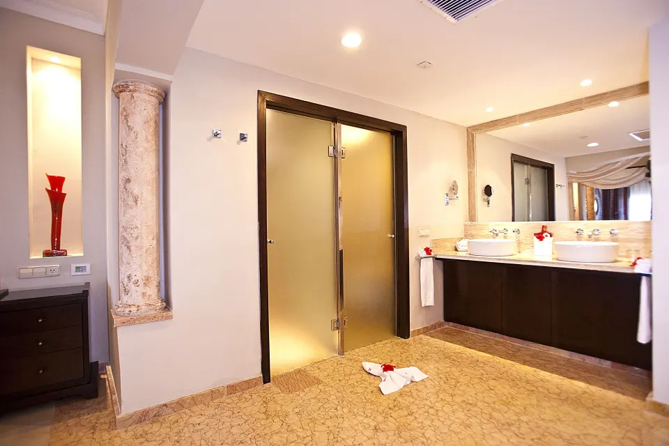 Junior Suite bathroom vanity and shower doors at Majestic Elegance Punta Cana.