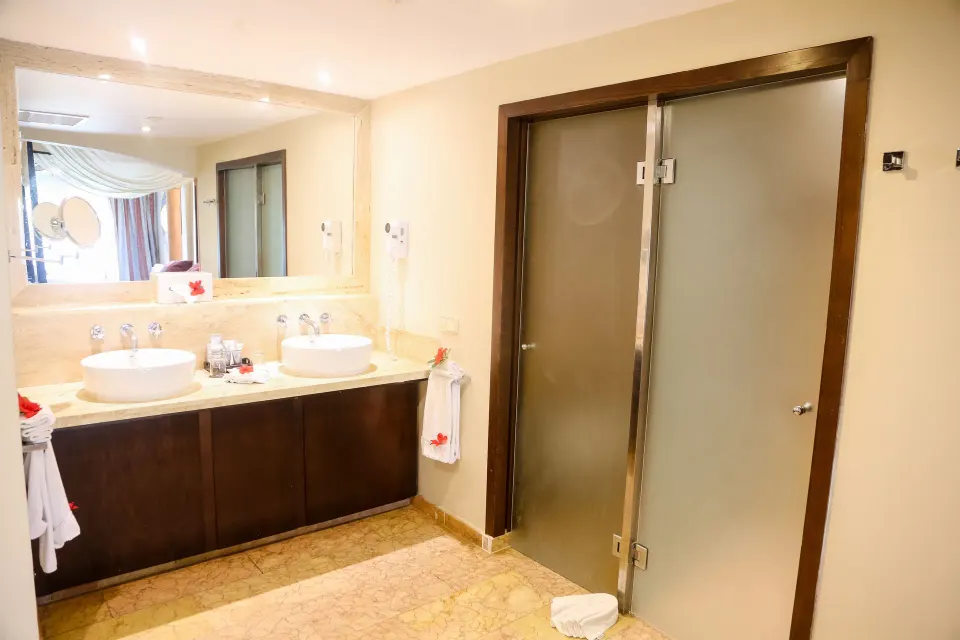 Junior Suite bathroom sinks and frosted shower doors at Majestic Elegance Punta Cana.