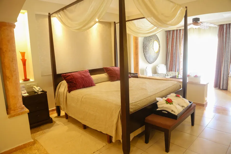Canopy bed beside a bright sitting area in a Junior Suite at Majestic Elegance Punta Cana.