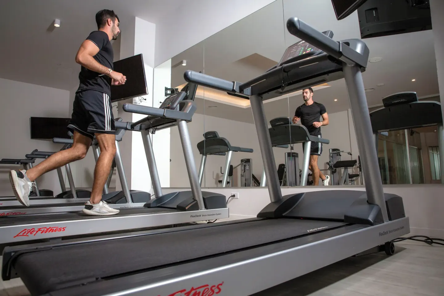 Guest runs on a treadmill in the fitness room at Majestic Mirage Costa Mujeres.
