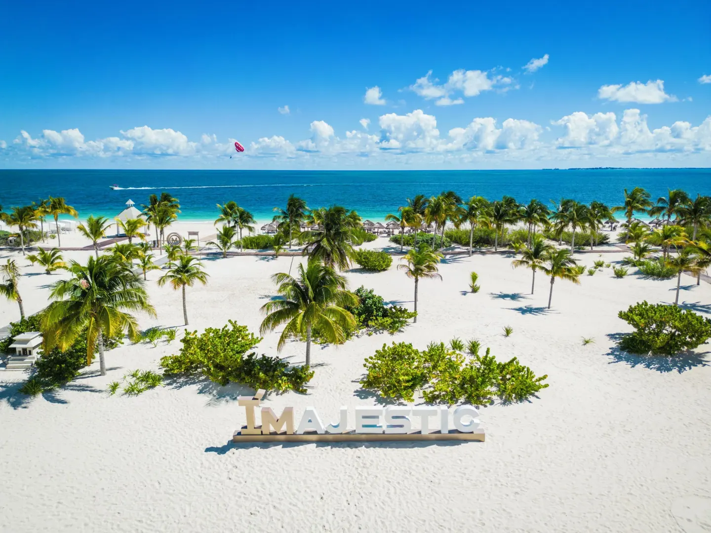 Palm-lined beach with Majestic sign at Majestic Mirage Costa Mujeres