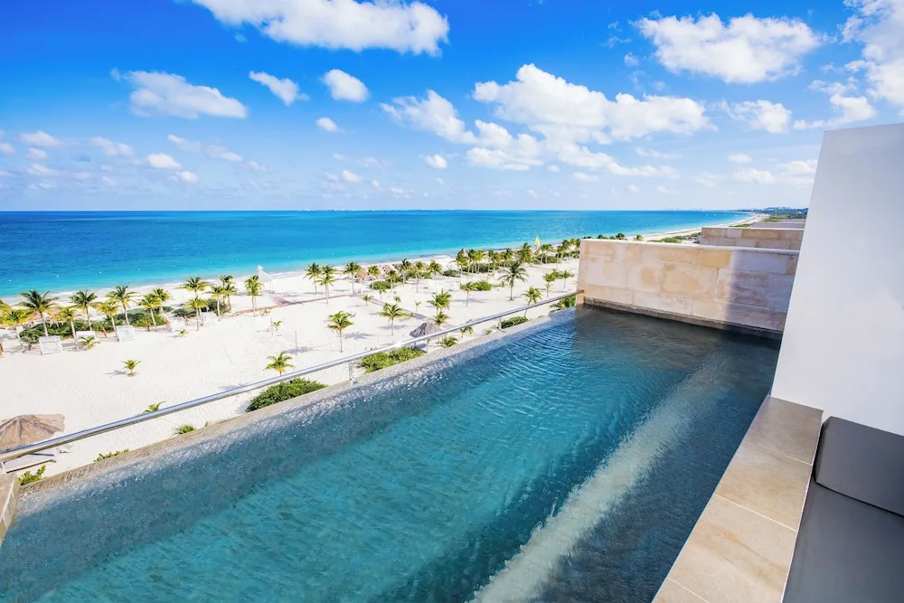 Rooftop pool overlooking the beach and turquoise sea at Majestic Mirage Costa Mujeres.