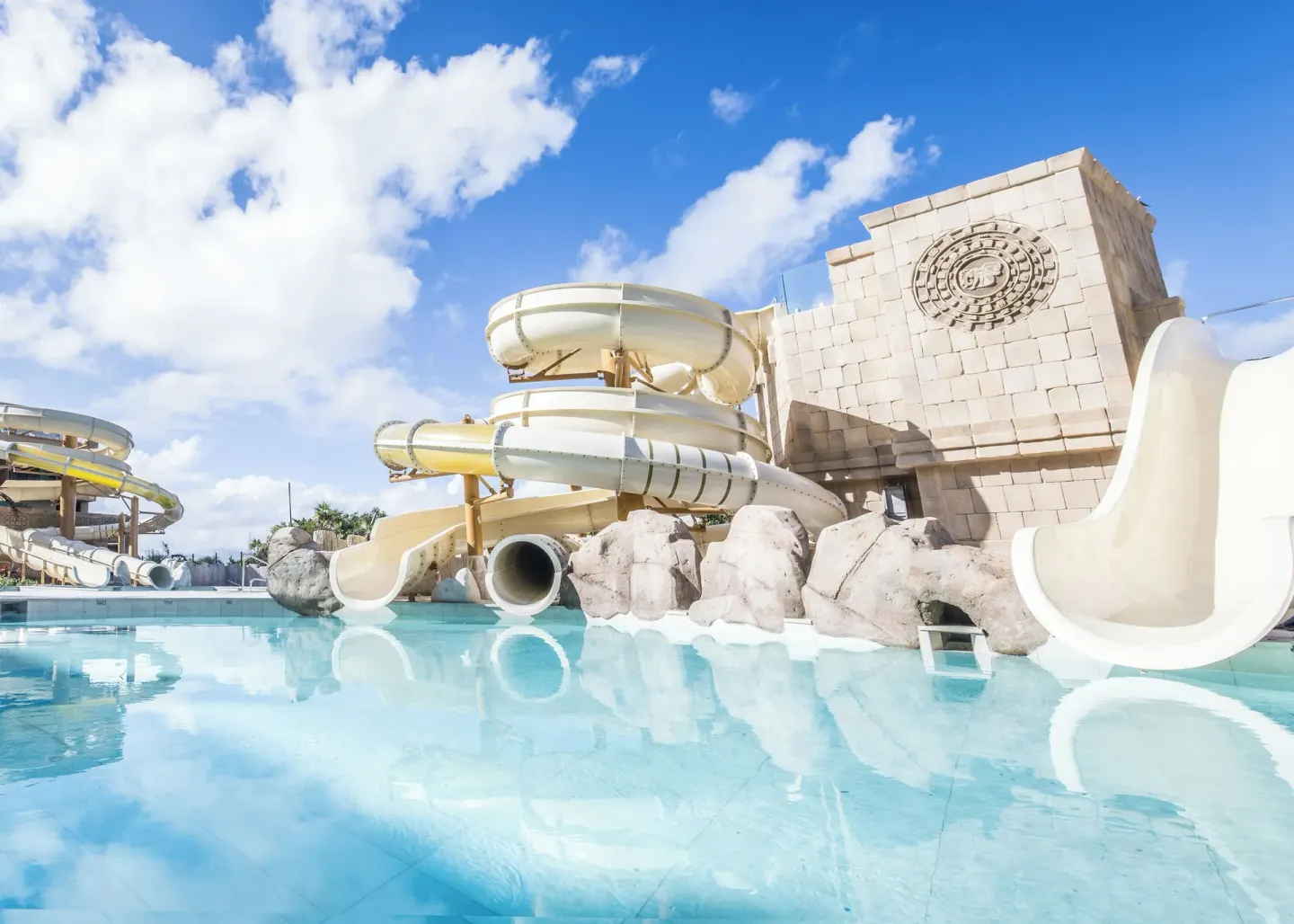 Water slides curve above a shallow pool at Majestic Mirage Costa Mujeres.