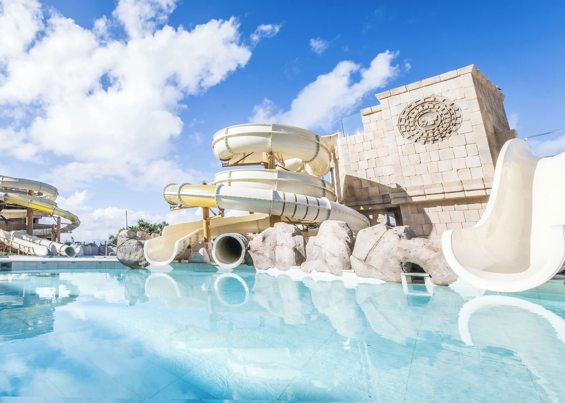 Water slides curve above a shallow pool at Majestic Mirage Costa Mujeres.