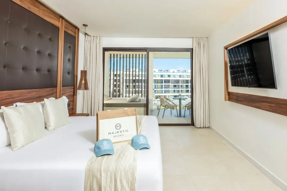 King bed and balcony doors in a Mirage Club One Bedroom Suite at Majestic Mirage Costa Mujeres.