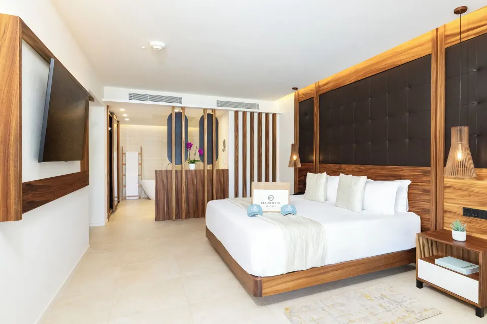 King bed and open bathroom area in a Mirage Club suite at Majestic Mirage Costa Mujeres.
