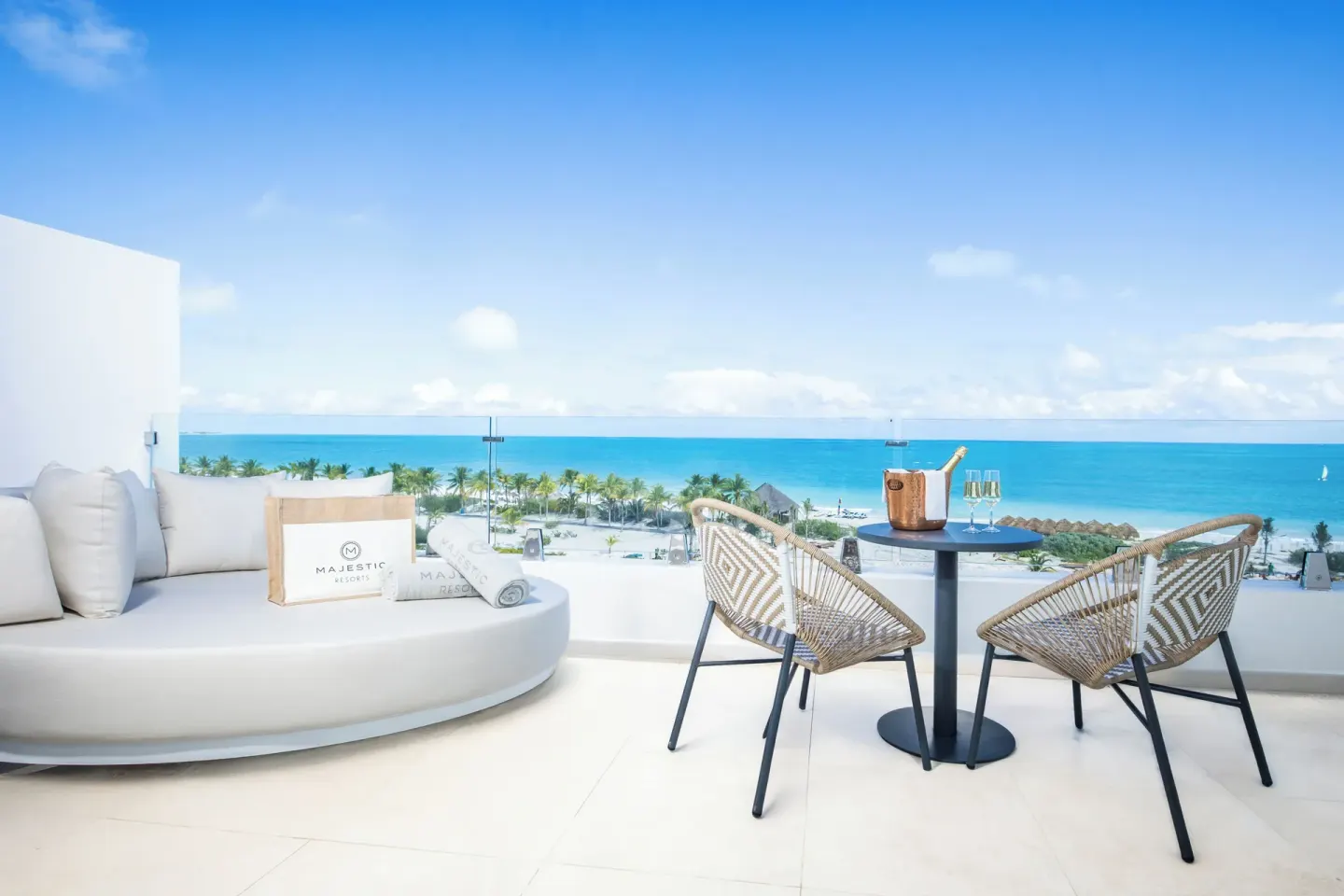 Oceanfront suite terrace with daybed and table at Majestic Mirage Costa Mujeres.