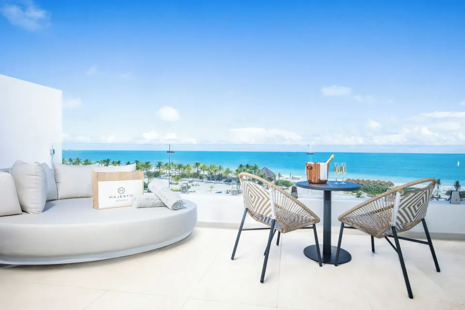 Oceanfront suite terrace with daybed and table at Majestic Mirage Costa Mujeres.