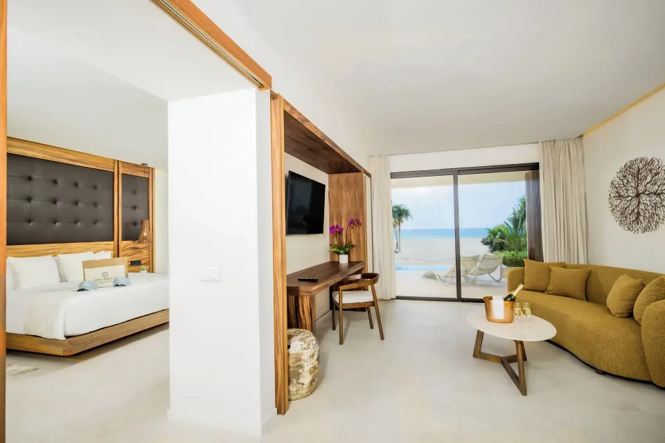 Oceanfront swim-up suite living room and bedroom at Majestic Mirage Costa Mujeres.