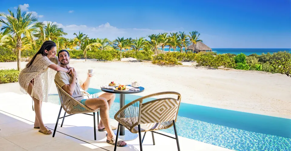 Couple dining on a swim-up oceanfront terrace at Majestic Mirage Costa Mujeres.