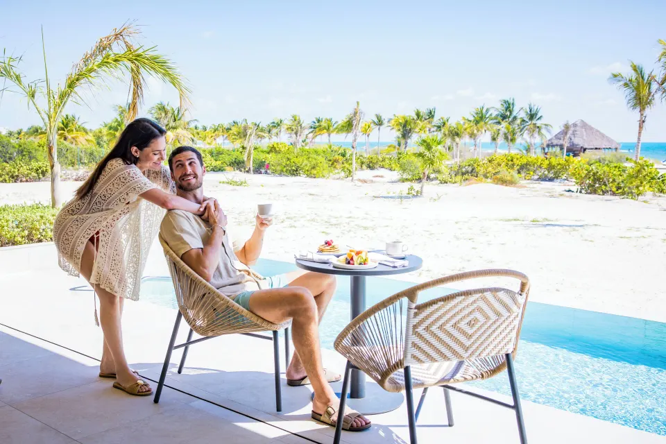 Couple at an oceanfront swim-up suite terrace at Majestic Mirage Costa Mujeres.