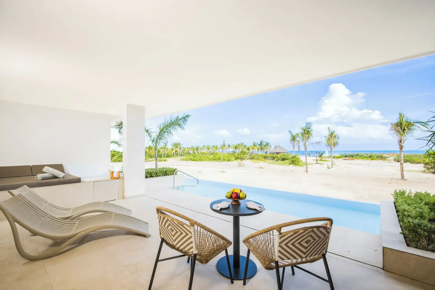Oceanfront swim-up terrace with loungers and seating at Majestic Mirage Costa Mujeres.
