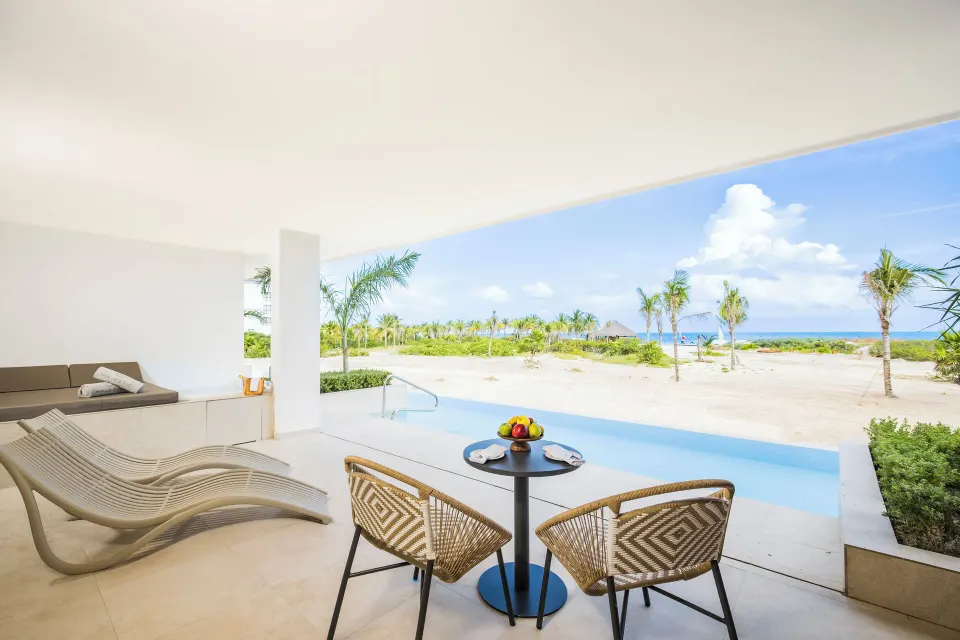 Oceanfront swim-up terrace with loungers and seating at Majestic Mirage Costa Mujeres.