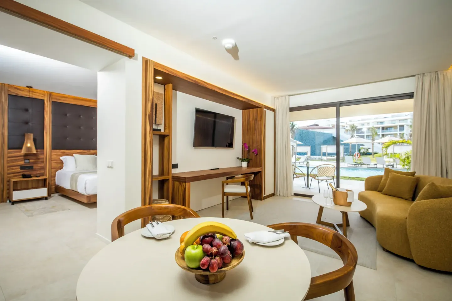 Mirage Club Swim-Up Suite living area and king bed at Majestic Mirage Costa Mujeres.