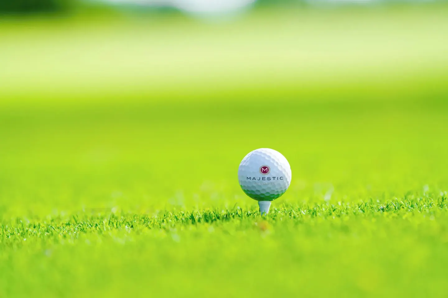 A Majestic golf ball sits on a tee in bright grass at Majestic Mirage Punta Cana.