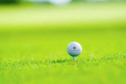A Majestic golf ball sits on a tee in bright grass at Majestic Mirage Punta Cana.