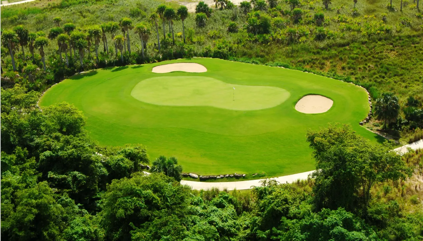 A manicured golf green with sand bunkers near Majestic Mirage Punta Cana.