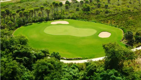 A manicured golf green with sand bunkers near Majestic Mirage Punta Cana.