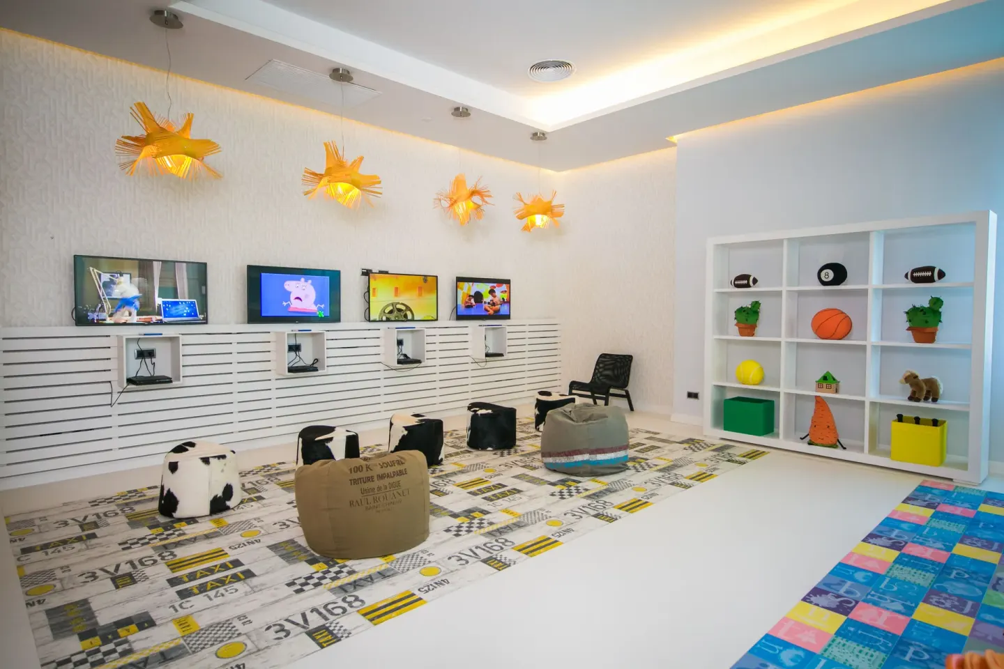 A kids game room with screens, beanbags, and toy shelves at Majestic Mirage Punta Cana.