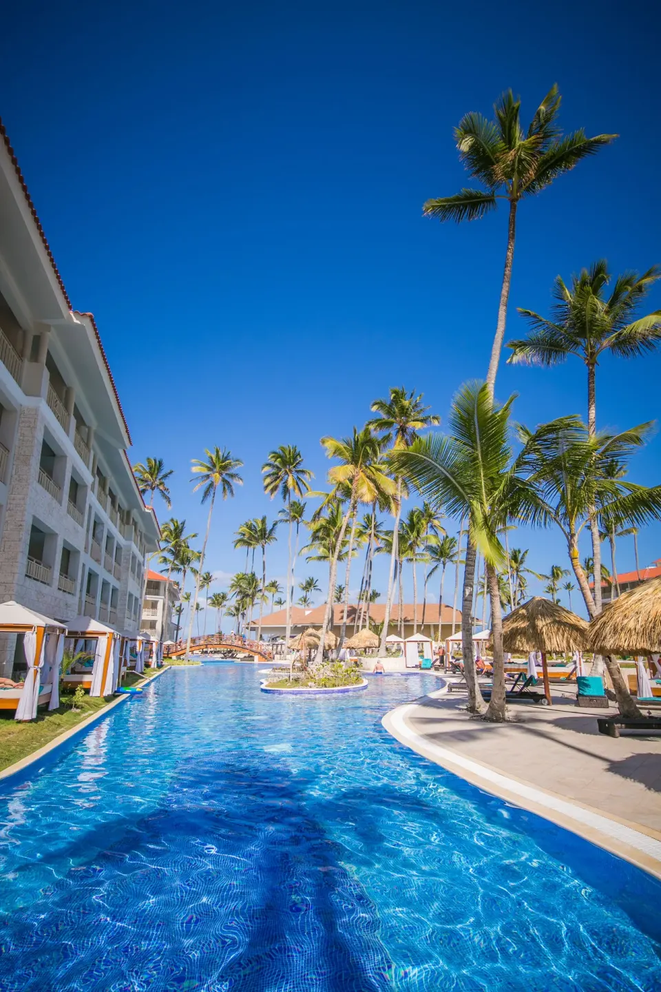 Long swim-up style pool corridor with palms and cabanas at Majestic Mirage Punta Cana.