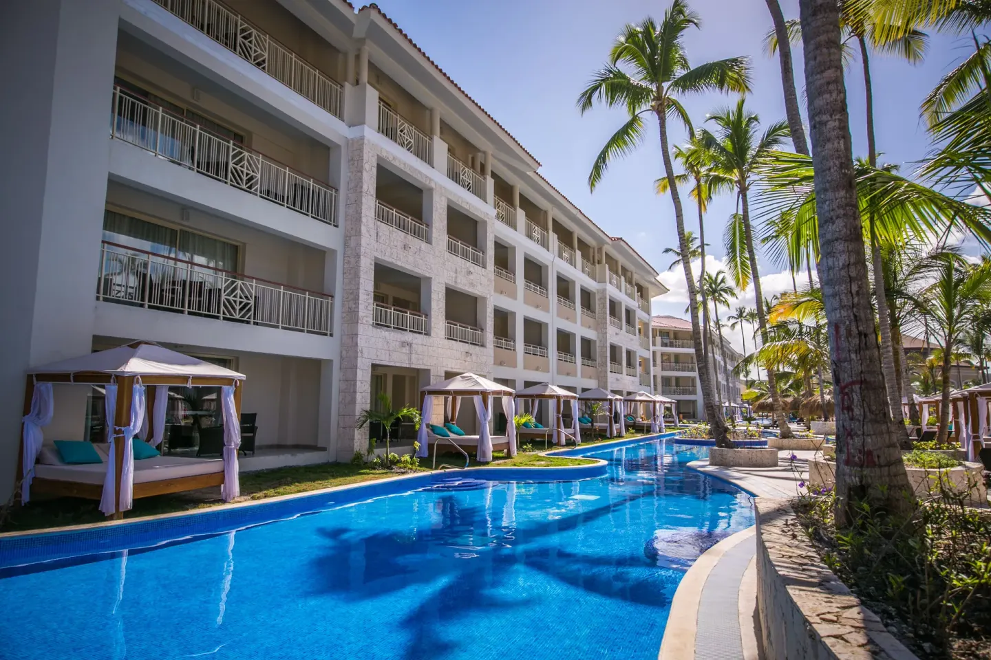 Guest-room building with balconies beside a narrow blue pool at Majestic Mirage Punta Cana.