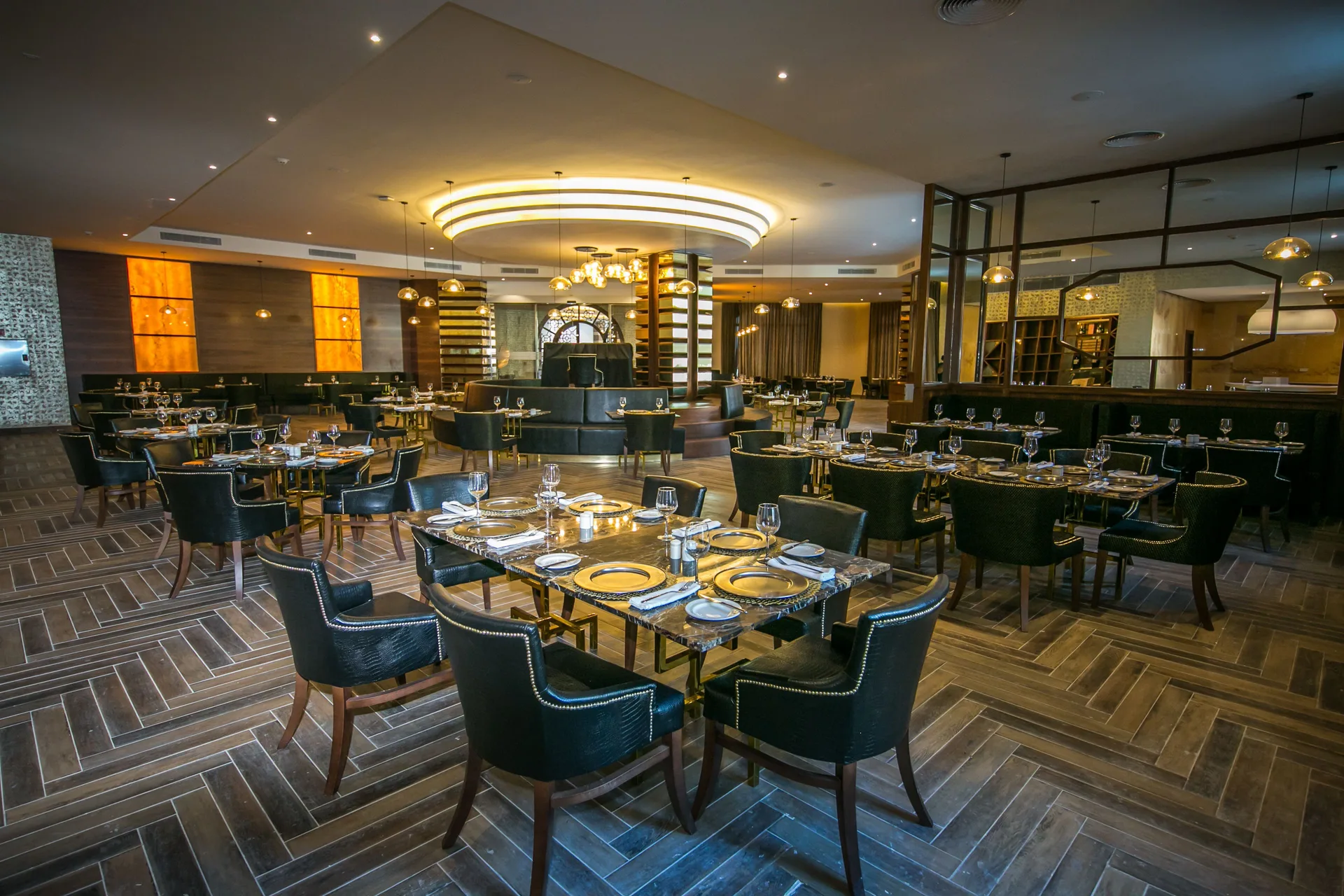 Steakhouse-style dining room with black chairs and set tables at Majestic Mirage Punta Cana.