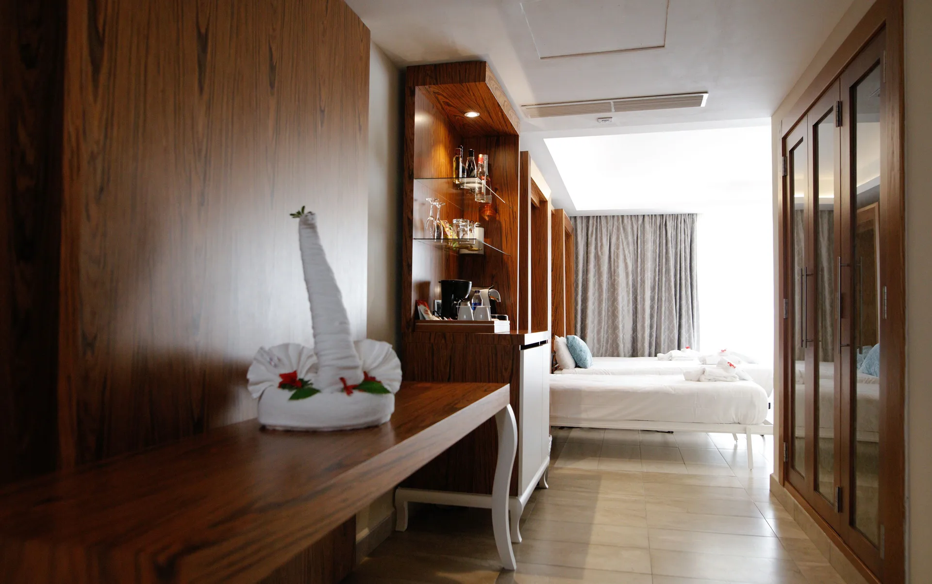 Family Suite with Outdoor Jacuzzi room desk, wet bar, wardrobes, and bed at Majestic Mirage Punta Cana.