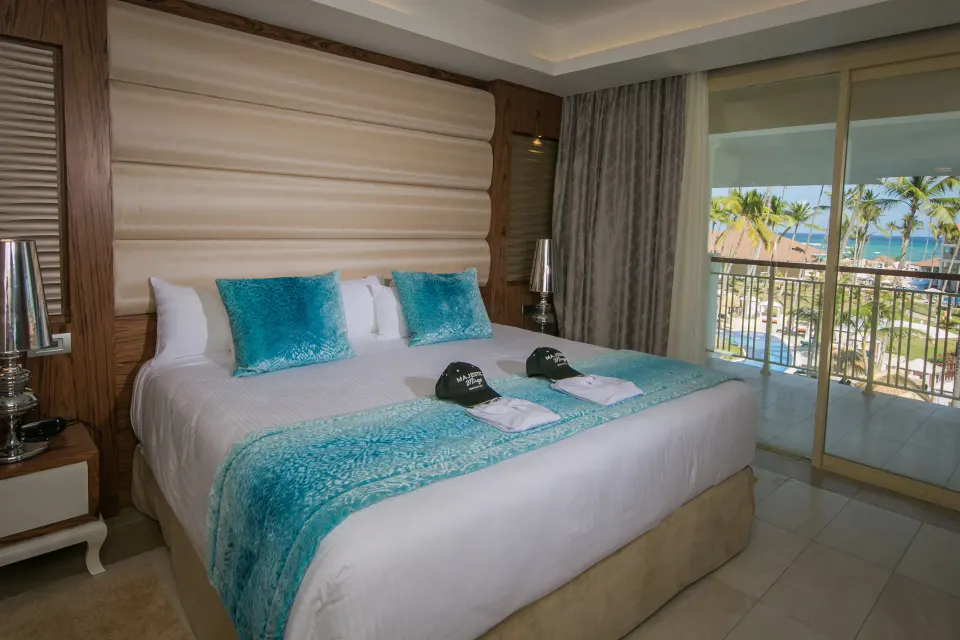 King bed and balcony ocean view in a Mirage Club suite at Majestic Mirage Punta Cana.