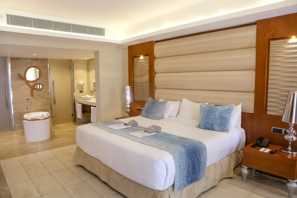 King bed beside an open bath and Jacuzzi tub at Majestic Mirage Punta Cana.