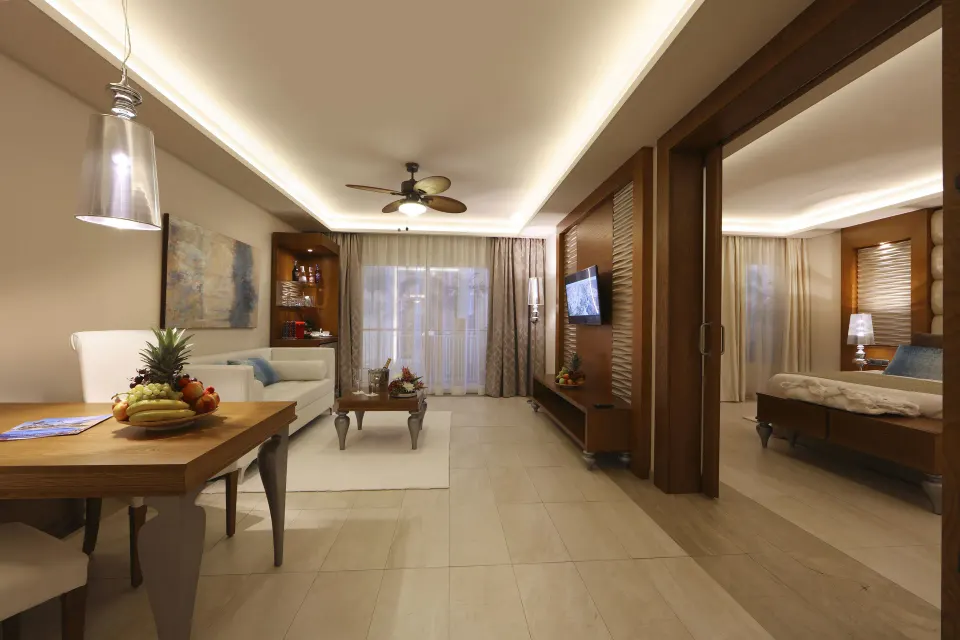 Living and dining area with bedroom entry in a suite at Majestic Mirage Punta Cana.