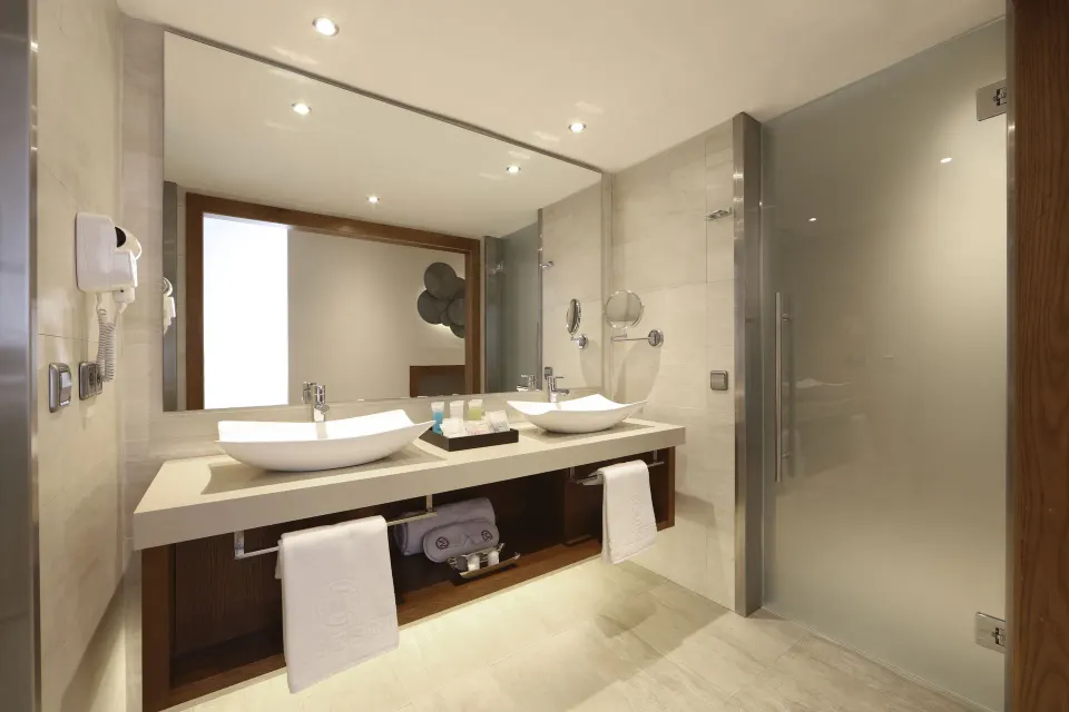 Sky View Suite bathroom with double sinks and glass shower at Majestic Mirage Punta Cana.