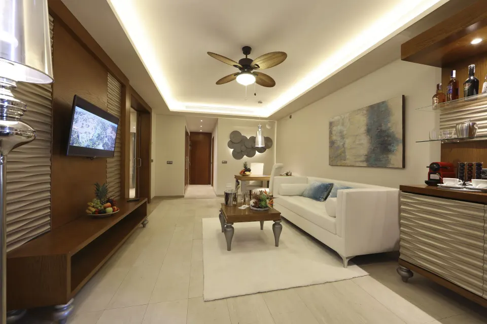 Swim Up Suite living room with sofa and minibar at Majestic Mirage Punta Cana.
