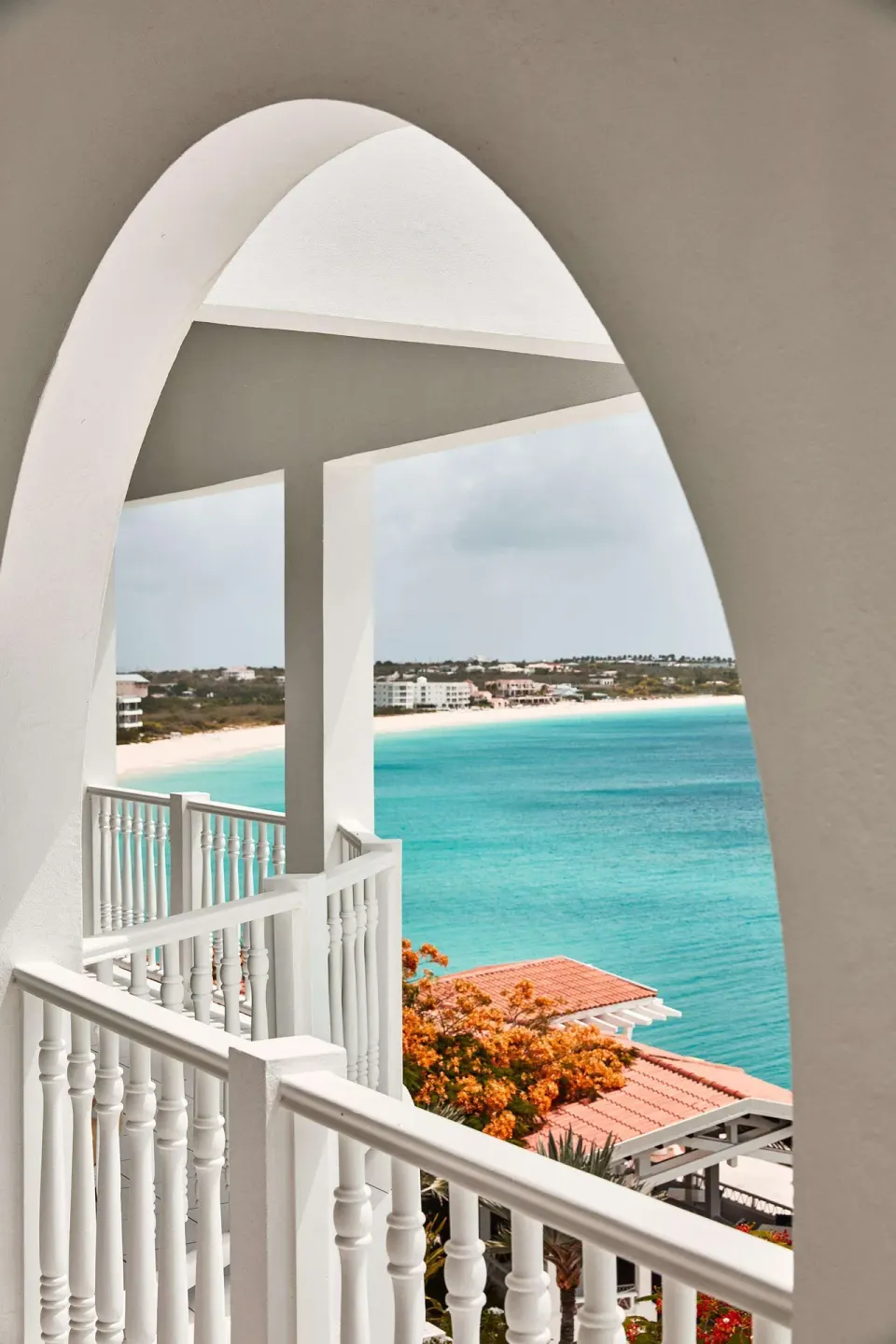White arched balcony overlooking turquoise water at Malliouhana Resort Anguilla.