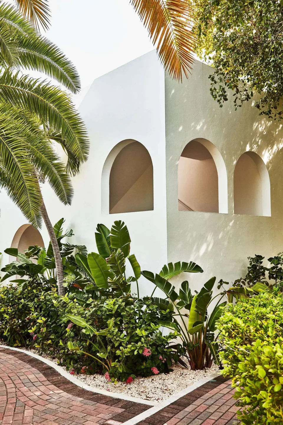 White arched resort building surrounded by tropical landscaping at Malliouhana Resort Anguilla.