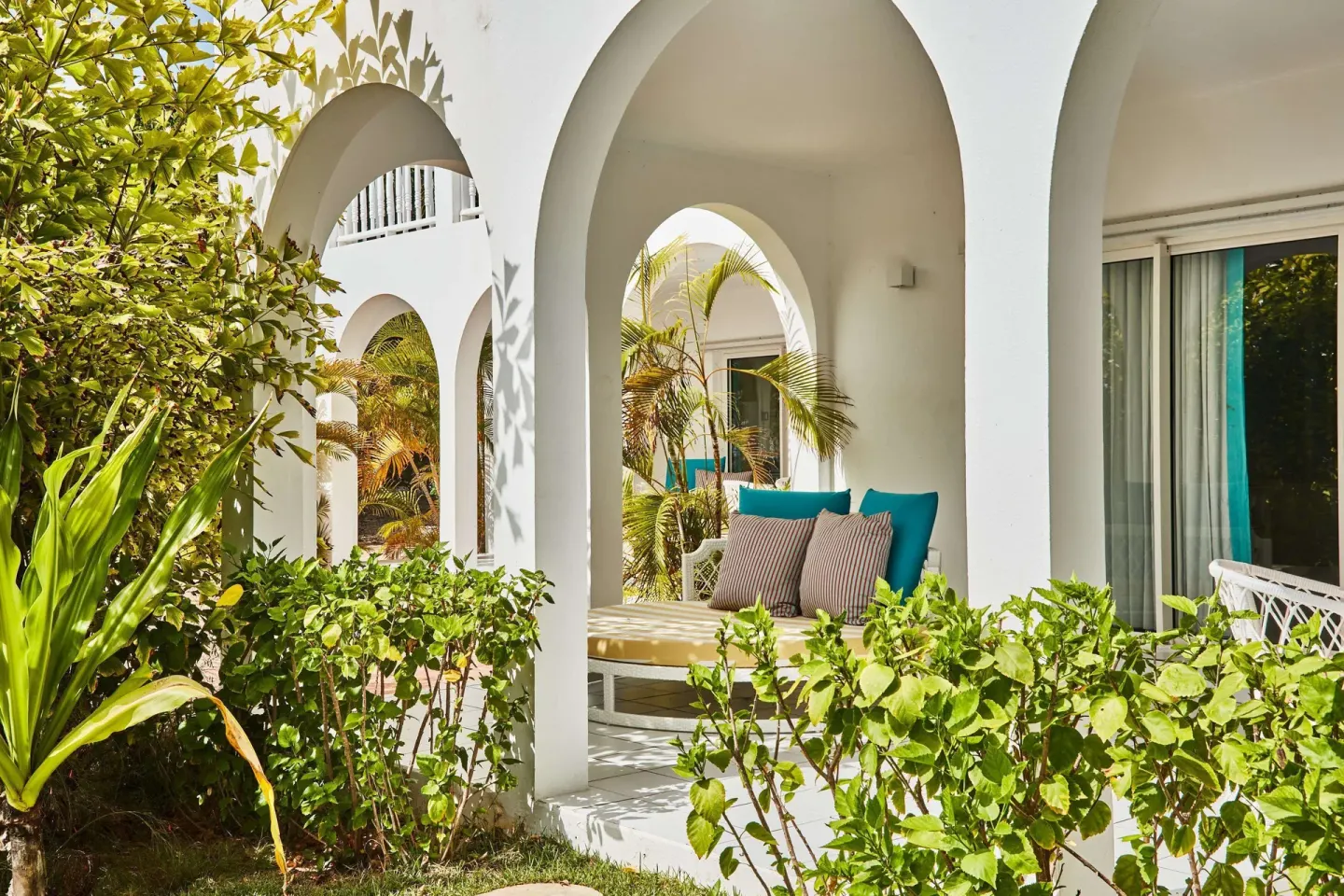Garden-level terrace with arched patio and daybed at Malliouhana Resort Anguilla.