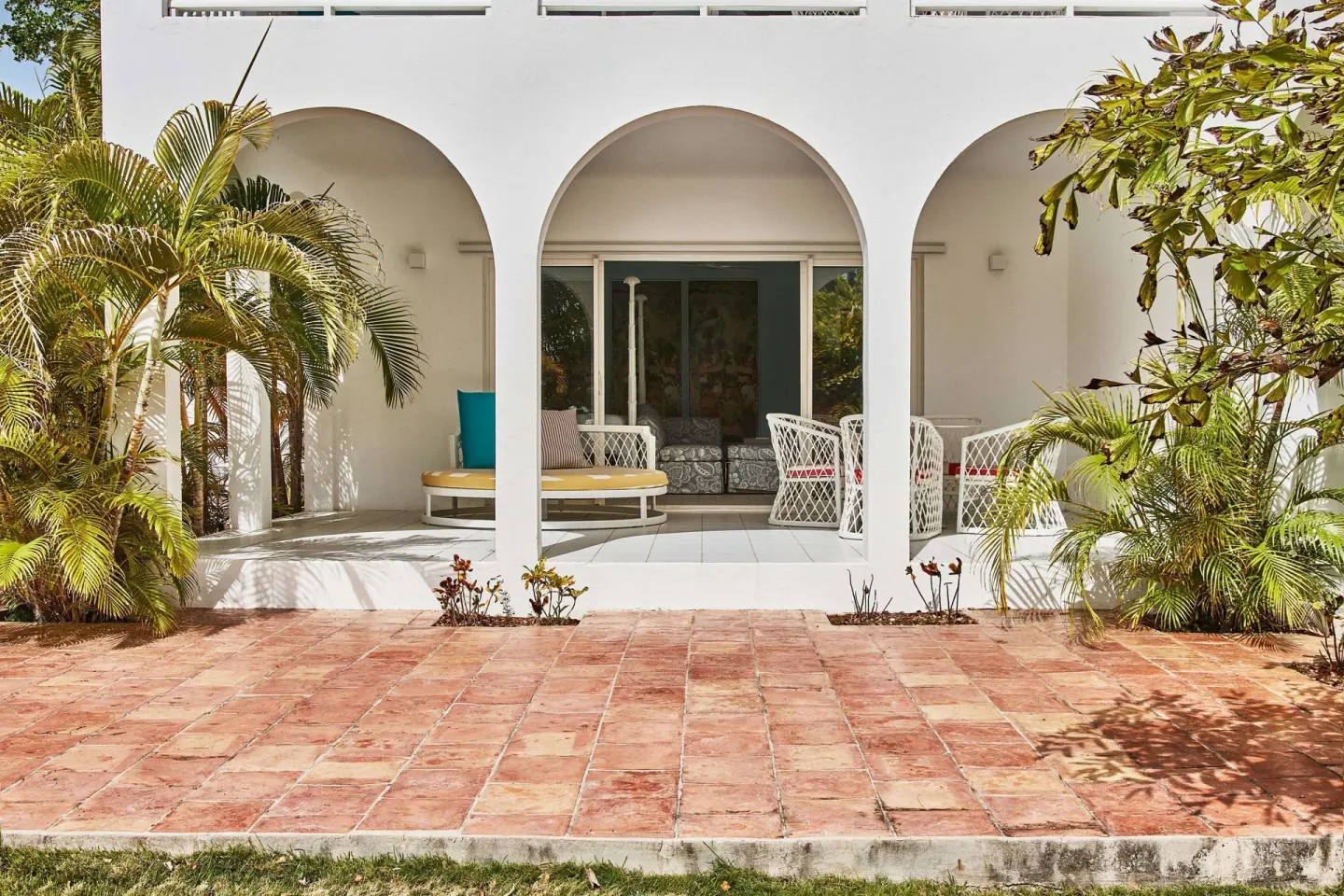White arched guest terrace with tropical plants at Malliouhana Resort Anguilla.