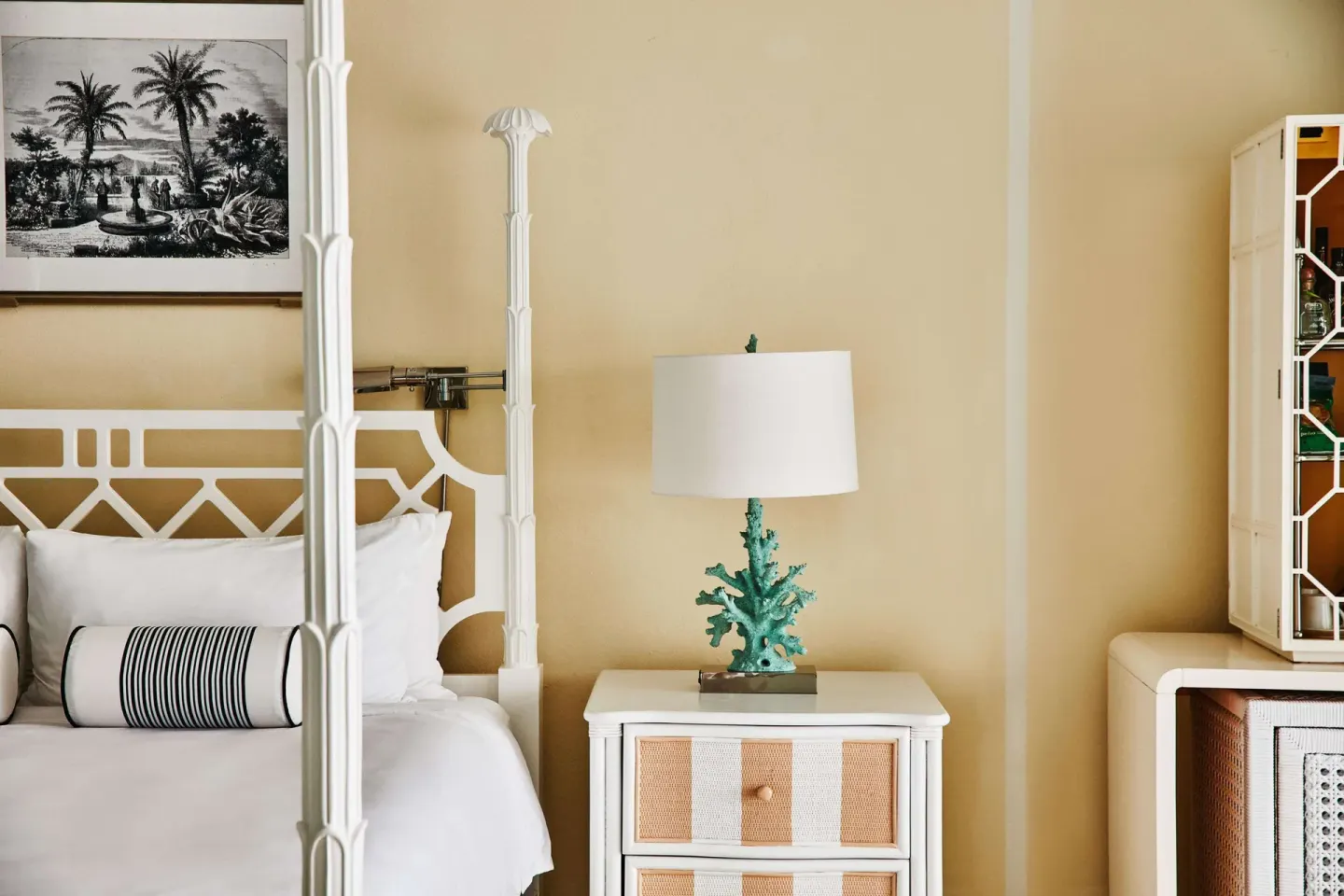 King bed detail with bedside lamp and tropical artwork at Malliouhana Resort Anguilla.
