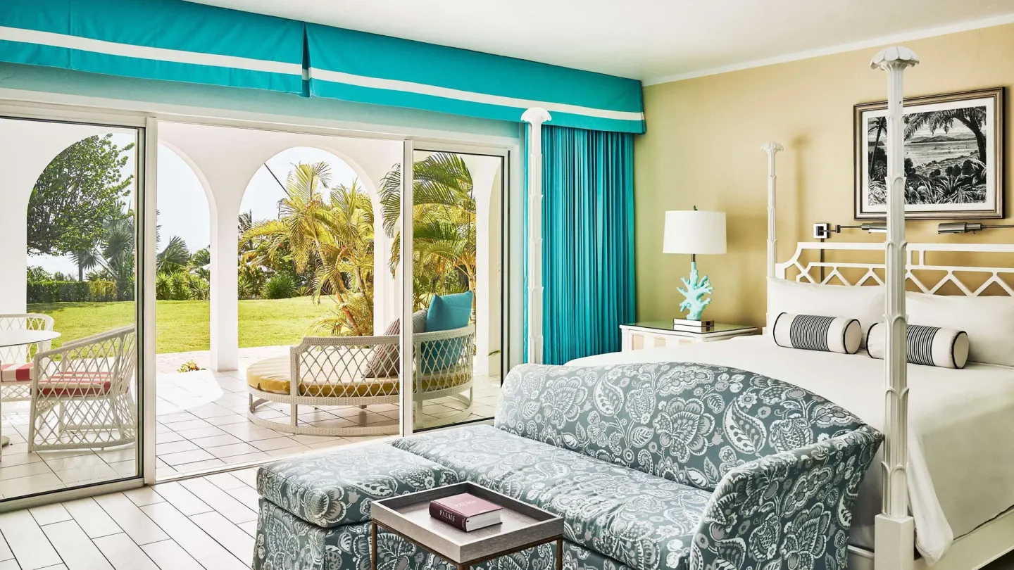 Guest room with four-poster king bed and garden terrace at Malliouhana Resort Anguilla.