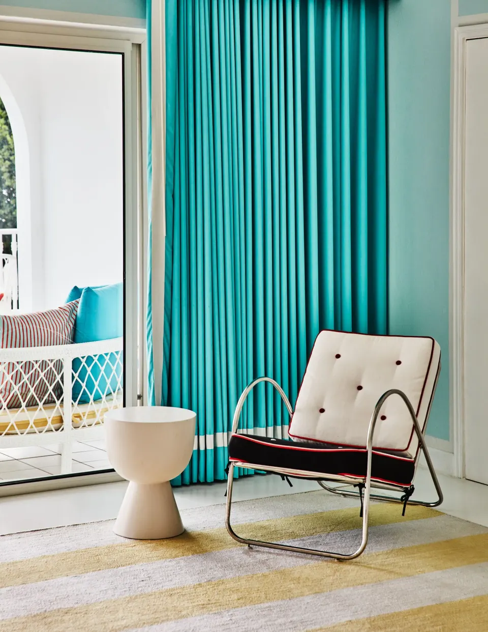 Guest room sitting corner with turquoise drapes at Malliouhana Resort Anguilla.