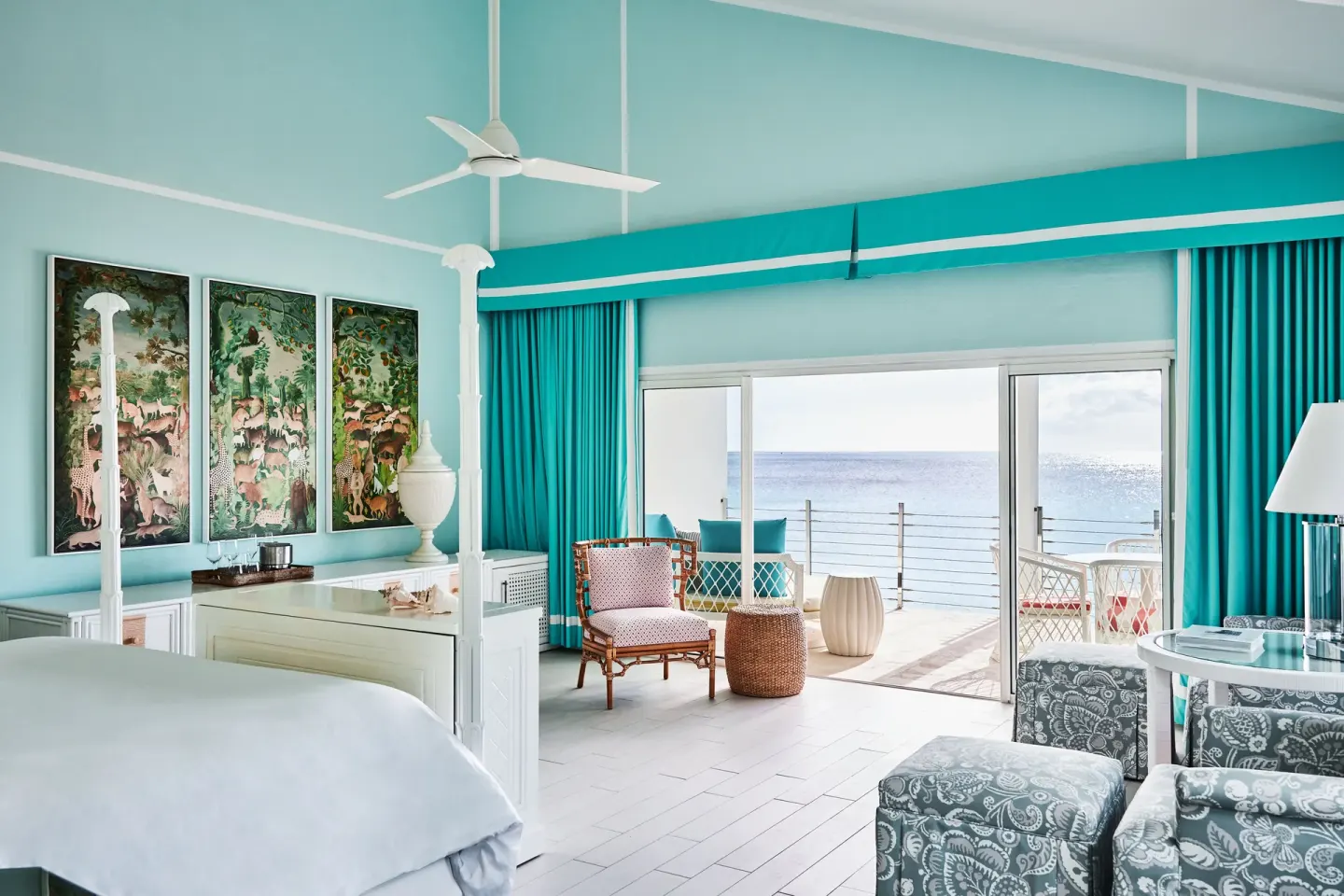 King bed room with turquoise curtains and an ocean balcony at Malliouhana Resort Anguilla.