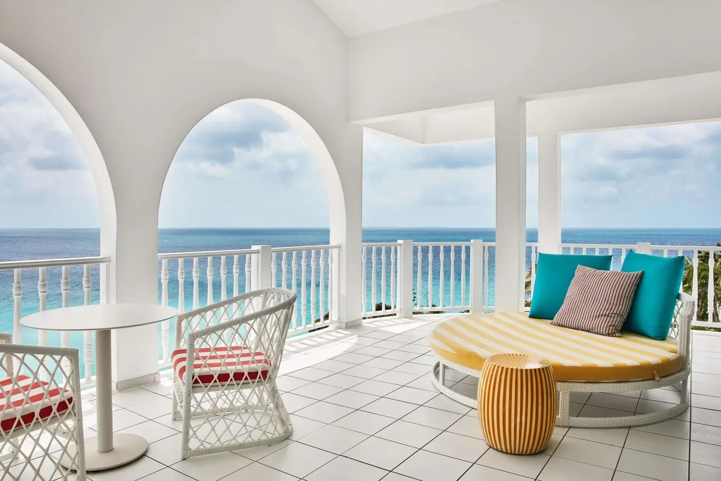 Arched ocean-view balcony with lounge seating at Malliouhana Resort Anguilla.
