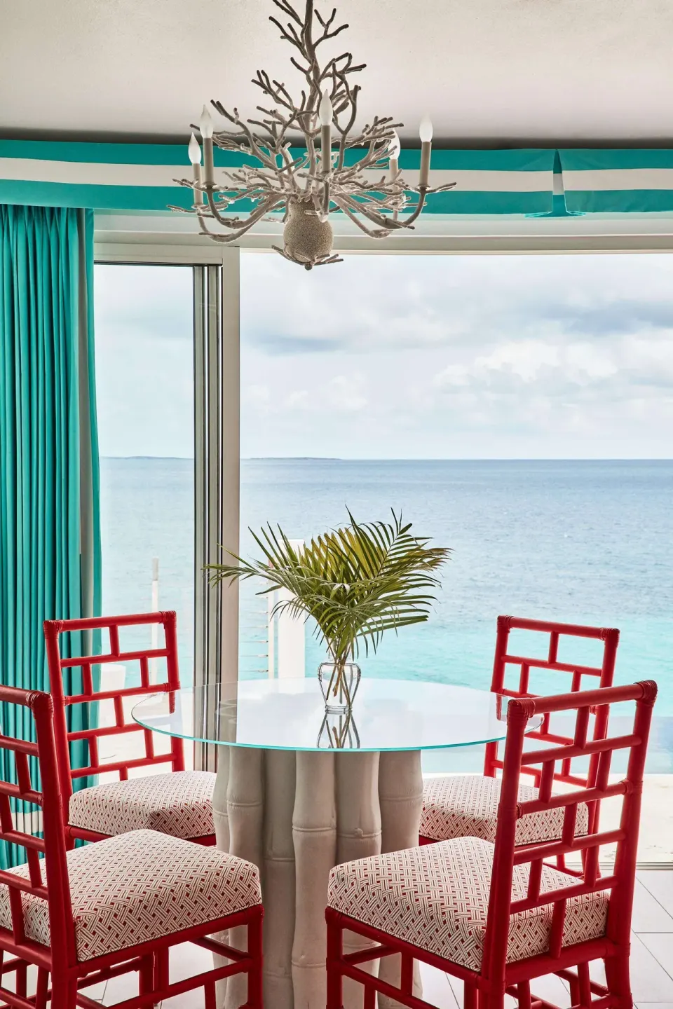 Ocean-view dining nook with red chairs at Malliouhana Resort Anguilla.
