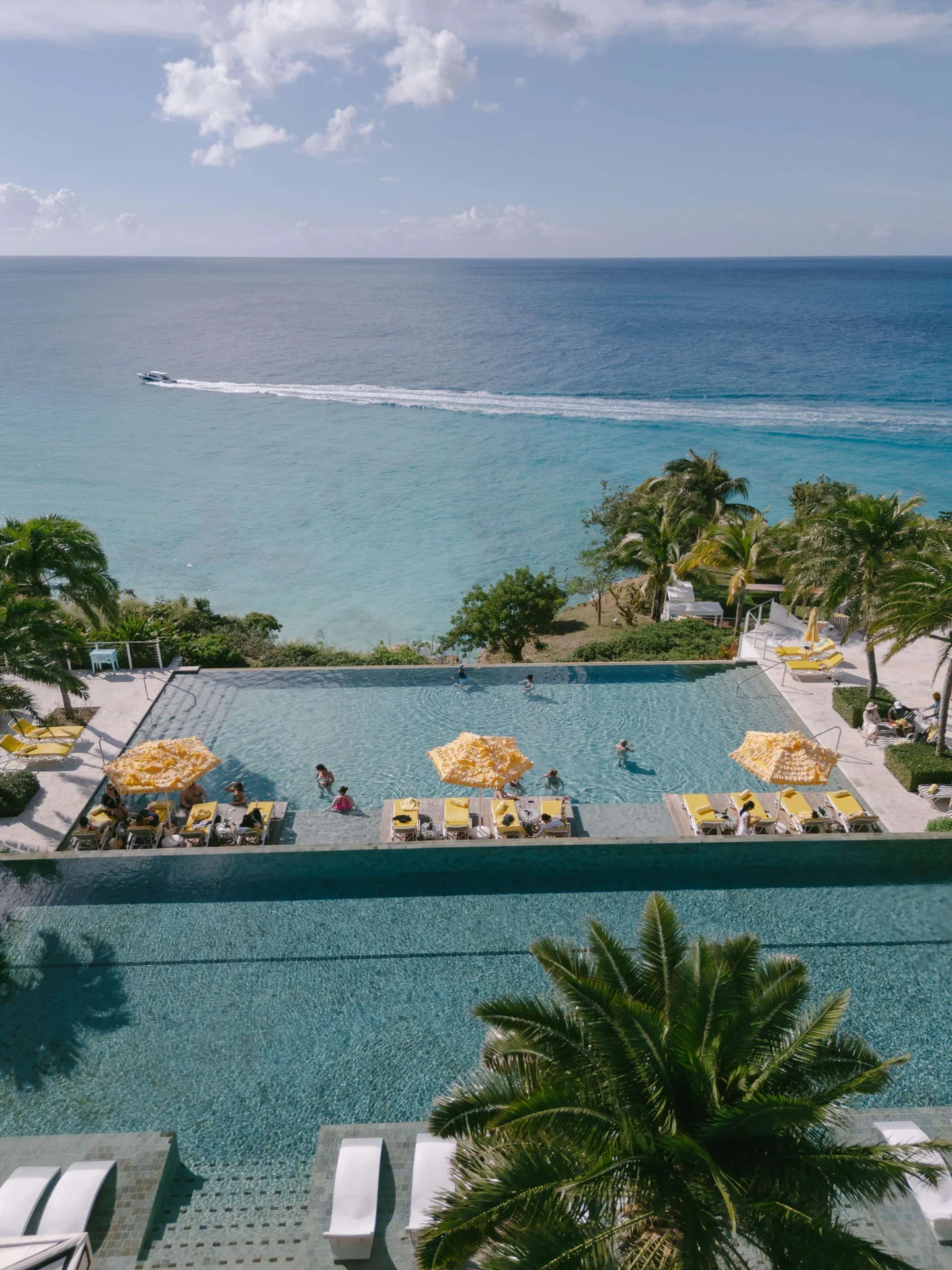 Oceanfront infinity pools with yellow loungers at Malliouhana Resort Anguilla.
